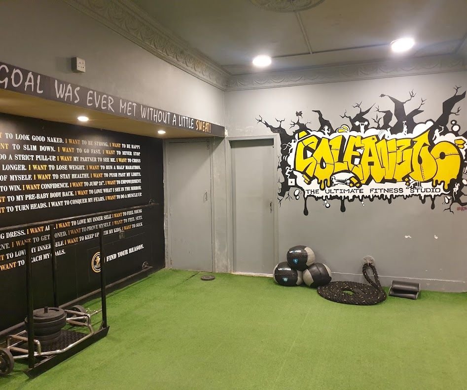 Green turf zone with sled, medicine balls and battle rope